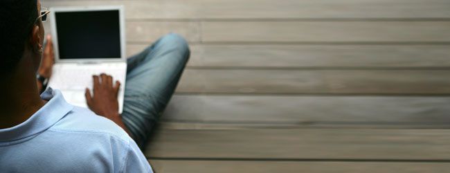 Man sitting on the floor using laptop